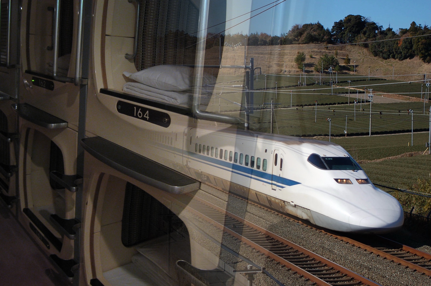 Photograph of a capsule hotel by Syced on Wikimedia Commons, and photograph of a 700 series Shinkansen by Sui-setz on Wikimedia Commons
